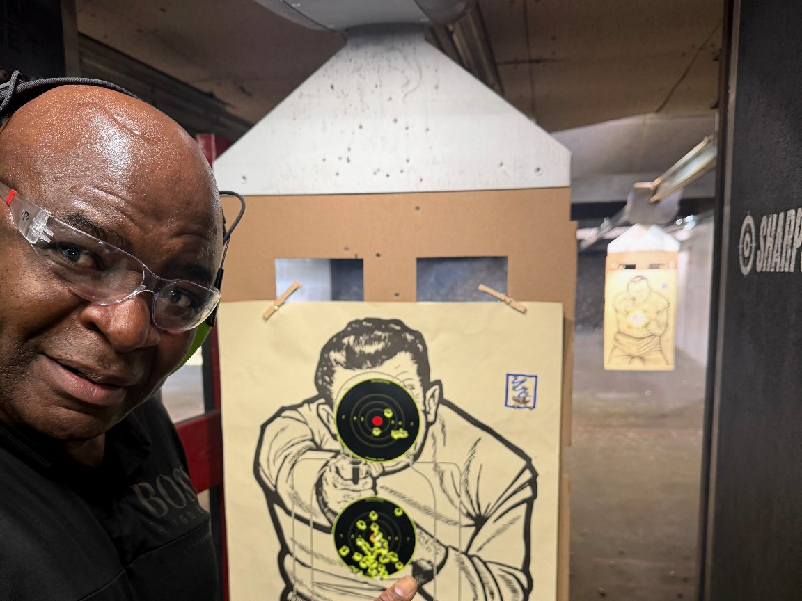 Student pointing to tight groupings on his target after a coaching session